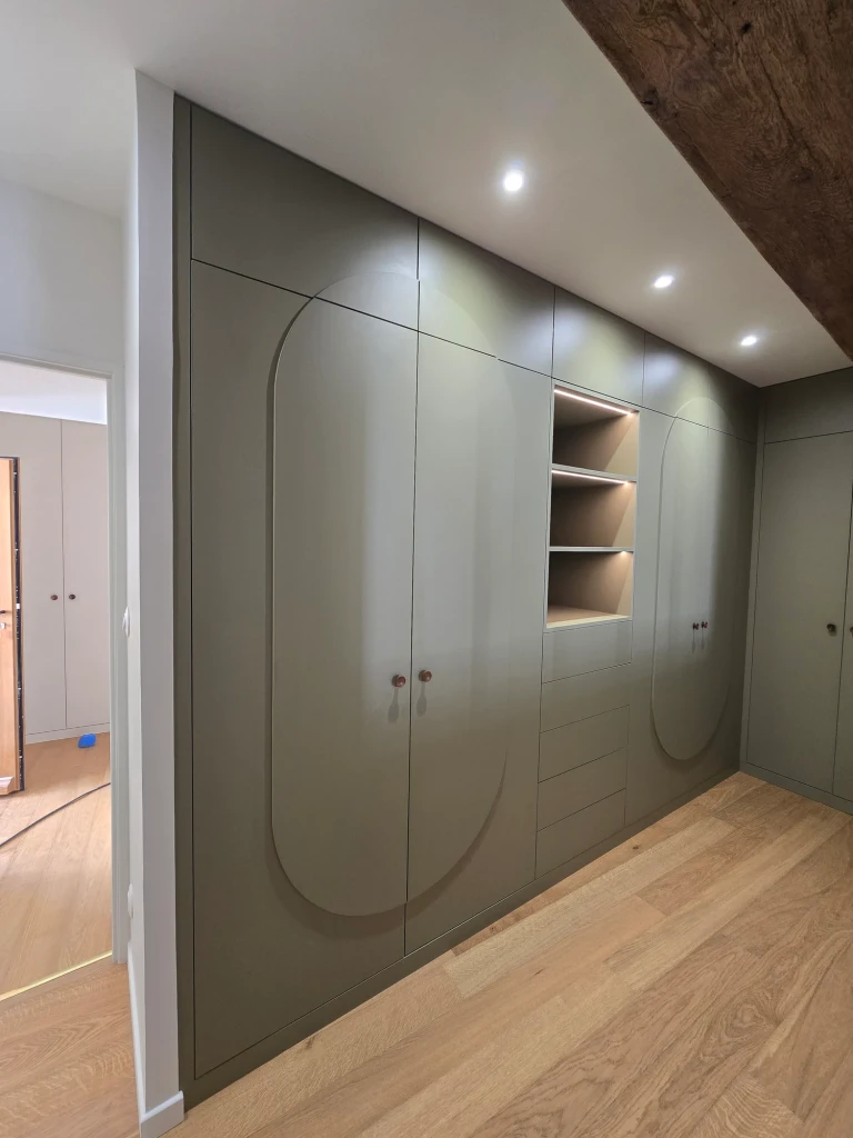 Rangements sur mesure réalisés par Bastien De Almeida : façades vertes aux motifs arrondis et niches éclairées