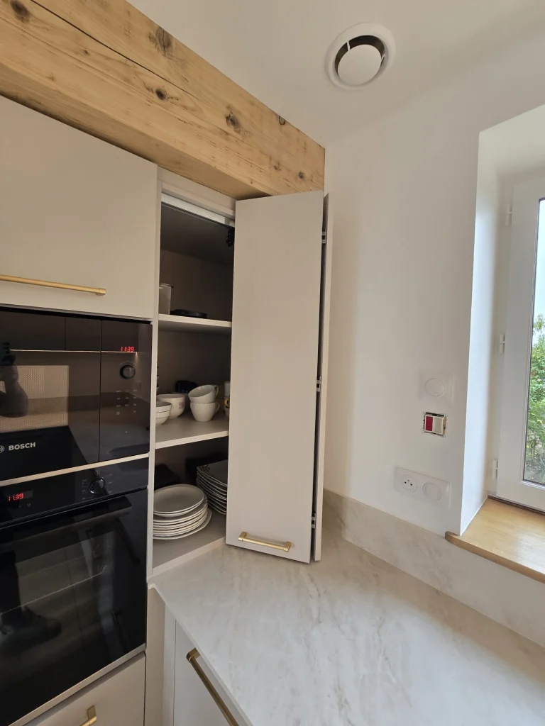 Placard de cuisine ouvert à côté des fours encastrés